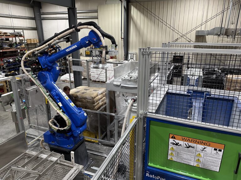 Yaskawa robotic arm depalletizing bags of agricultural products in a manufacturing plant.